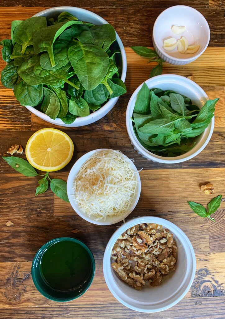 Ingredients for spinach pesto pasta: Spinach, garlic, lemon, parmesan cheese, basil, olive oil, walnuts.