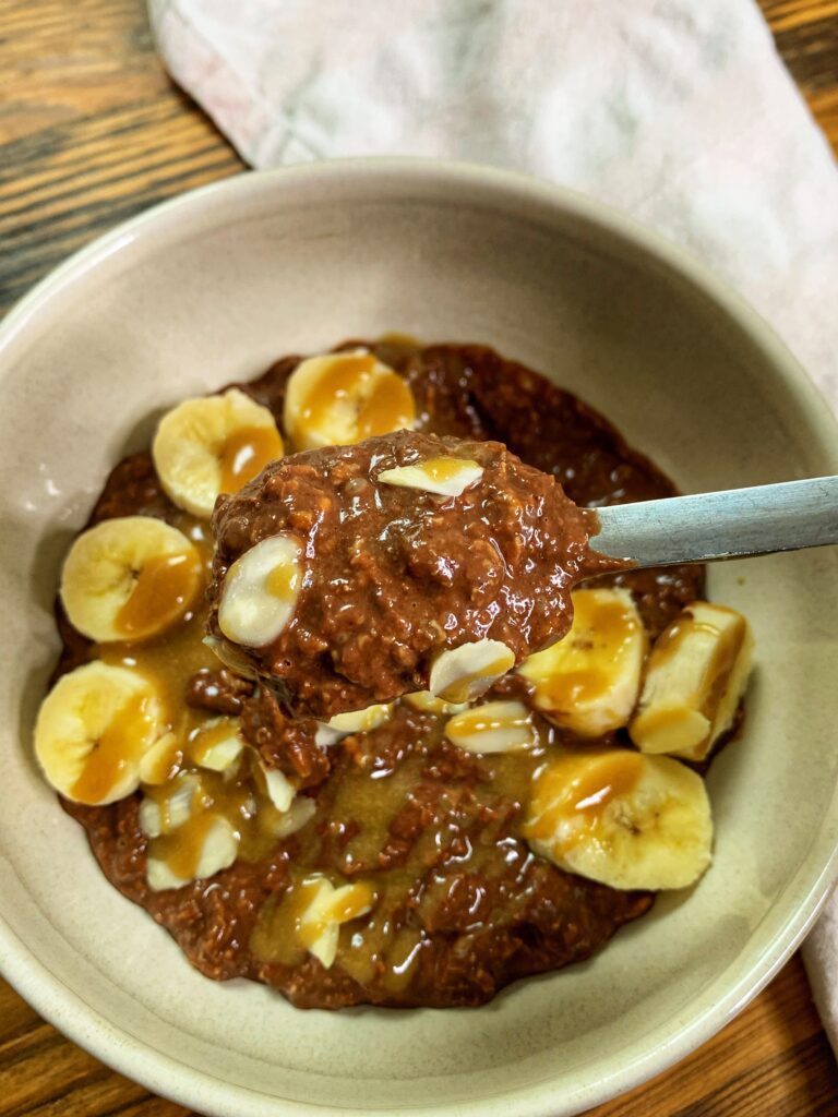 Brownie batter overnight oats, served with banana and tahini maple caramel