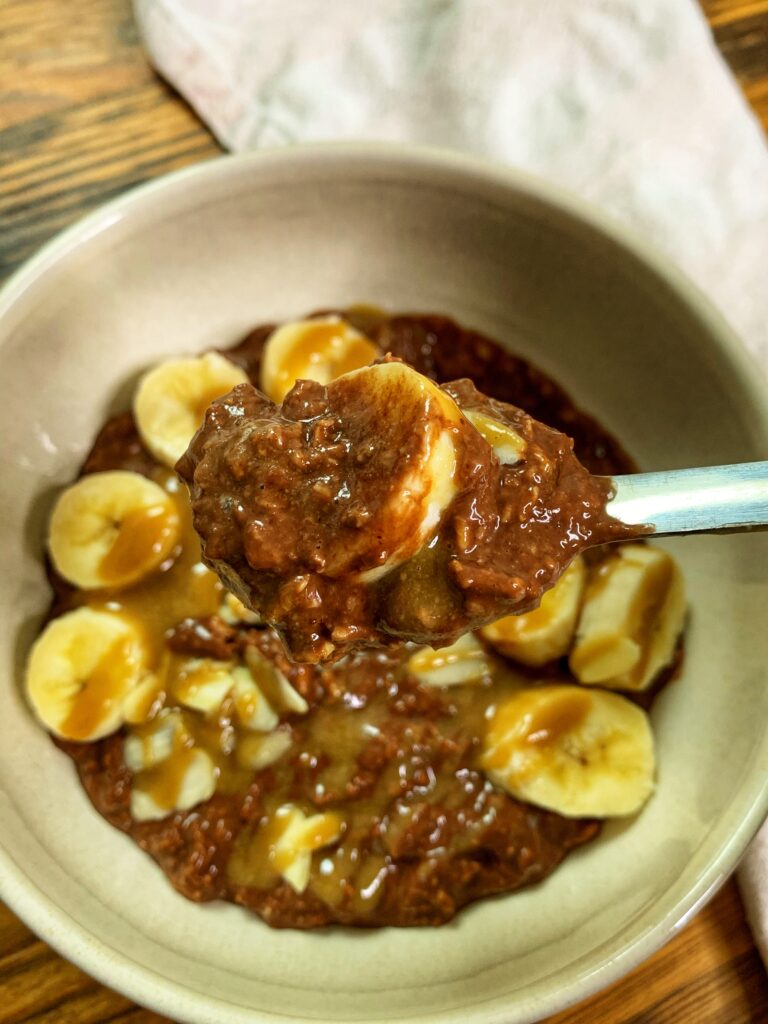 Brownie batter overnight oats, served with banana and tahini maple caramel